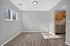 Bright dining area with modern wood flooring and natural light, adjacent to a kitchen with stainless steel appliances and warm wooden cabinets.