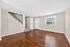 Bright and spacious living area with elegant hardwood floors and a stylish staircase, perfect for modern living.