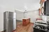 Modern kitchen with sleek stainless steel appliances, granite countertops, and stylish island lighting, creating an inviting open concept space.