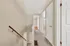 Inviting hallway with carpeted flooring leading to bright, spacious rooms with white doors and ample natural light.