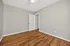 Bright and spacious bedroom with polished hardwood floors and neutral walls, offering a sleek and modern canvas for personalization.
