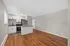 Modern open-concept living area with sleek hardwood floors, elegant cabinetry, and a stylish kitchen featuring stainless steel appliances.