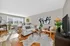 Inviting living room with abundant natural light, cozy seating, modern art, and stylish decor.