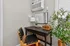 Cozy workspace featuring a sleek black desk, modern lamp, and vibrant potted plant, perfect for productivity and style.