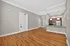 Bright and inviting open-plan apartment with hardwood floors, modern kitchen, and elegant lighting fixtures.