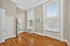 Bright and spacious room with elegant hardwood floors, large windows, and modern fixtures, perfect for a serene living space.