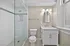 Elegant bathroom featuring a sleek glass shower, modern vanity with marble countertop, and stylish lighting fixtures.