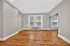 Bright living area with fresh hardwood floors, neutral-toned walls, and large windows inviting natural light.