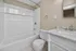 Elegant bathroom showcasing a pristine white bathtub, sleek marble vanity, and contemporary fixtures, exuding luxury and style.