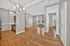 Inviting open-concept apartment showcasing elegant hardwood floors, a modern kitchen space with sleek cabinetry, and abundant natural light from large windows.