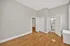 Spacious bedroom with hardwood floors, neutral walls, and ensuite bathroom, perfect for modern living.