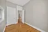 Bright room with elegant hardwood floors and classic white doors, leading to a light-filled living space.