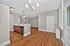 Modern open-concept living space with sleek hardwood floors, a stylish kitchen island, and elegant lighting fixtures.