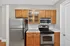 Modern kitchen with stainless steel appliances, elegant wooden cabinetry, and polished countertops.