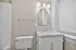 Elegant bathroom with a marble countertop, sleek white vanity, and modern fixtures offering a touch of luxury.