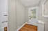 Charming entryway featuring a wooden floor, neutral walls, and a glass-paneled door providing natural light.