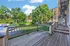 Charming wooden deck with serene views of lush greenery and historic brick buildings, perfect for relaxing or entertaining.