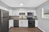 Contemporary kitchen with stainless steel appliances, sleek granite countertops, and elegant white cabinetry, featuring a cozy window view.