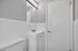 Modern bathroom with sleek white vanity, elegant mirror, and soft lighting, offering a clean and fresh atmosphere.