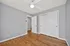 Bright bedroom with sleek hardwood floors, modern ceiling fan, and ample closet space.