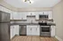 Modern kitchen with sleek design, featuring stainless steel appliances, white cabinetry, and granite countertops.