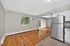 Bright and airy open-concept living space with hardwood floors, modern kitchen, and sliding glass doors leading to a serene outdoor area.