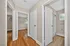 Inviting hallway with elegant hardwood floors leading to bedrooms and a modern bathroom with natural light.