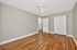 Spacious bedroom with elegant hardwood floors, neutral walls, and a ceiling fan providing comfort and style.