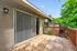 Charming outdoor patio with sliding glass doors, surrounded by lush greenery, perfect for relaxation.