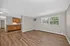Bright and spacious living area with elegant wood flooring and an open kitchen, featuring ample cabinet space and a cozy dining nook.