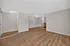 Spacious living area with elegant wood flooring and neutral walls, perfect for comfortable living.