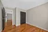 Bright bedroom featuring elegant hardwood floors, neutral walls, and a spacious closet.