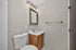 Bright and modern bathroom featuring a sleek white sink, stylish mirror, and contemporary lighting fixtures.