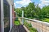Charming apartment balcony with a view of lush greenery and a clear blue sky, perfect for relaxation and outdoor enjoyment.
