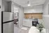 Charming modern kitchen with sleek stainless steel appliances, bright cabinetry, and a cozy dining area with elegant decor.