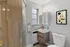 Stylish modern bathroom featuring a sleek glass shower, minimalist vanity, and elegant wall art, creating a serene and contemporary space.