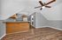 Charming attic living space featuring an open kitchen with wooden cabinetry and a cozy ceiling fan, perfect for intimate gatherings.