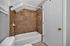 Chic bathroom with elegant tiled walls, modern bathtub, and sleek fixtures, offering a fresh and inviting atmosphere.