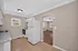 Bright kitchen with ample counter space and modern appliances, opening to a cozy living area with warm wood flooring.
