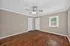 Bright room with polished hardwood floors, neutral walls, and a ceiling fan, offering a cozy and inviting space.