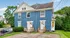 Charming blue duplex with front porches, nestled in a lush suburban neighborhood.