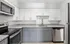 Modern kitchen with stylish granite countertops, stainless steel appliances, and elegant two-tone cabinetry.
