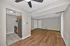 Modern open-plan living area with sleek hardwood floors, adjacent to a compact kitchen with stainless steel appliances and elegant tile flooring.