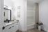 Elegant bathroom featuring a granite countertop, modern fixtures, and a stylish patterned shower curtain.