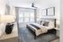 Bright and modern bedroom with elegant decor, featuring a cozy bed, stylish lamps, and large windows with natural light.