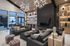 Chic modern living room with stylish lighting fixtures, plush dark sofas, and elegant decorative accents, perfect for luxurious entertaining.