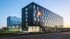 Modern apartment building with sleek glass windows and contemporary design at dusk.
