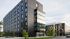 Modern apartment complex with sleek design and large windows set in an urban environment.