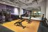 Stylish gym with modern exercise equipment, mirrored wall, and vibrant mural.
