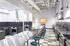 Contemporary kitchen space featuring stainless steel appliances, a long communal table with stools, and modern industrial design.